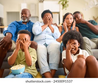 Frightened Multi-Generation Family Sitting On Sofa At Home Watching Horror Movie On TV Together - Powered by Shutterstock