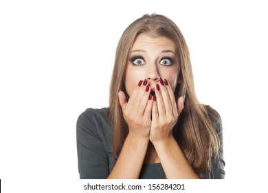 frightened and shocked girl with her hands in her mouth posing on white background