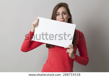 frightened young woman holding a message for copy space in front of her 