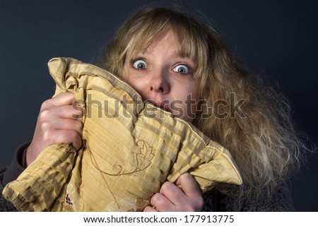 A frightened young woman watching a horror movie