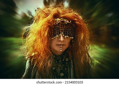 A frightening forest witch with a mask covering her eyes stands amidst the forest performing a mysterious ritual. Woman shaman. Paganism. Death ritual. Halloween. 