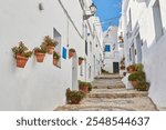 Frigiliana, narrow street with white walls and decorated with flower pots and flowers in the province of Malaga. Andalusia, Spain