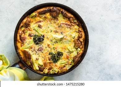 Frittata With Sausage And Vegetables In Skillet On Light Stone Background. Top View.