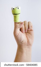 Frog finger puppet on index finger isolated on white background