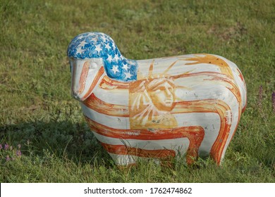 FROMUSHIKA NOVA VILLAGE, ODESSA OBLAST, UKRAINE - JUNE, 2020: Sculpture of colored Lambs in colors american flag on Green Grass in the village.  