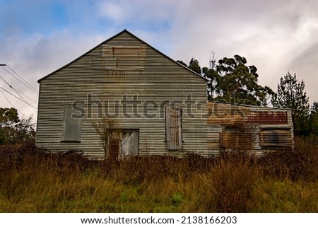 Front of abandoned run down tin shed rusting and decaying in a field