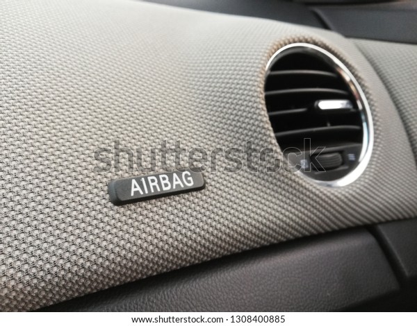 Front air bag on dashboard with air\
conditioning inside car closeup composition.\
