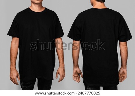 Front and back views of a man wearing a black, oversized t-shirt with blank space, ideal for a mockup, set against gray background.