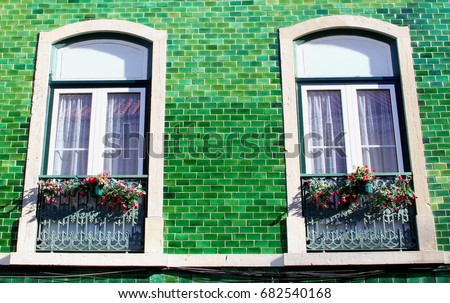 Front of beautiful green house, old azulejos, windows with Portuguese flowers, wrought iron balconies, Lisbon