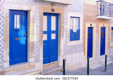 Front Of Beautiful Old Houses, Blue Doors And Typical Pink Portuguese Tiles (azulejos), Charming Neighborhood Street, Alfama, Lisbon