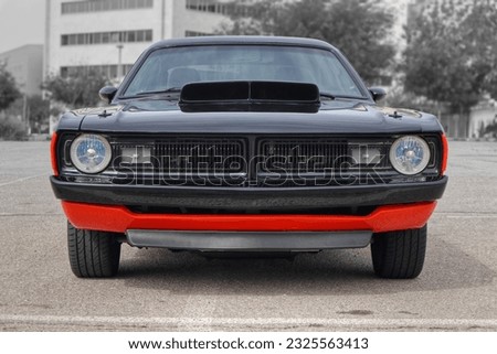 The front of a black and red American muscle car