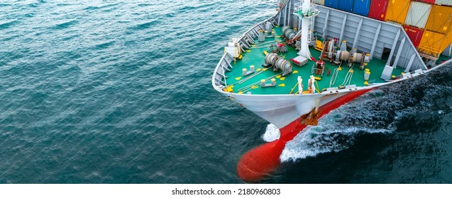 In Front Of Bow Nose Large Cargo Container Ship, Nose Of Vessel Cargo Ship. Close Up Front View Of Cargo Vessel On Blue Ocean Freight Forwarding Service