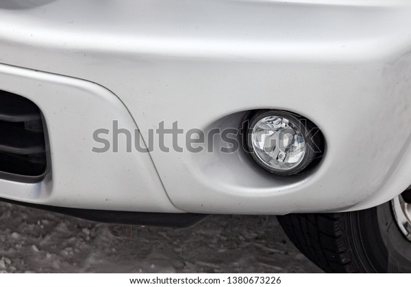 Front\
bumper fog lamp view of silver car after cleaning before sale in a\
workshop for repair and detailing vehicles auto service industry.\
Road safety while driving. Transportation\
lighting.
