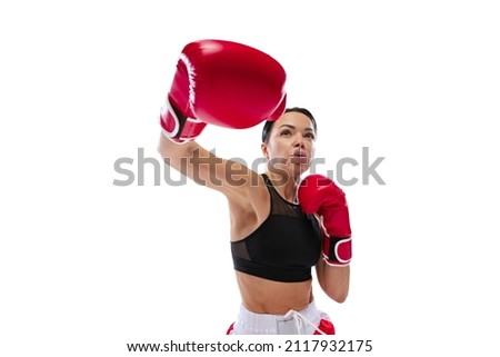 Front camera view of young girl, professional boxer practicing in sports uniform and boxing gloves isolated on white studio background. Sport, competition, show, power, action concept.