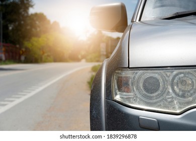 Front Of Car Sloppy And Close Up On Lamp. Stop Beside Road Relax From Driving Long Time. With Effect Of Light On Blurred Trees.