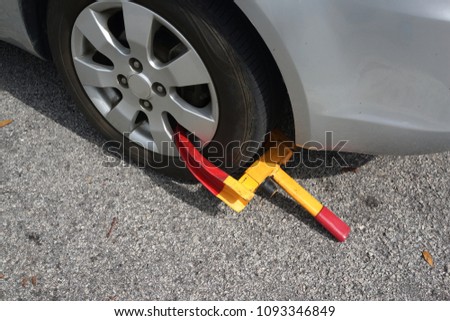 Front car wheel clamped for illegal parking at the road side, a violation car park.