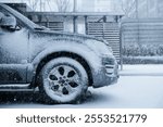 front car wheel piled up with snow in the parking lot