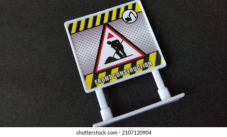 front construction notice sign toy on black background