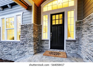 Front covered porch design boasts stone siding which creates immense curb appeal of luxurious home. Welcome mat lead to black front door accented with sidelights framed by white siding.
Northwest, USA