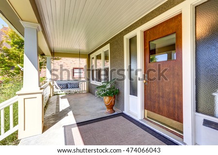 Front covered porch with hanging swing and flower pot. Northwest, USA