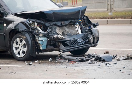 Front of dark color car damaged and broken by accident on the road.  - Shutterstock ID 1585270054