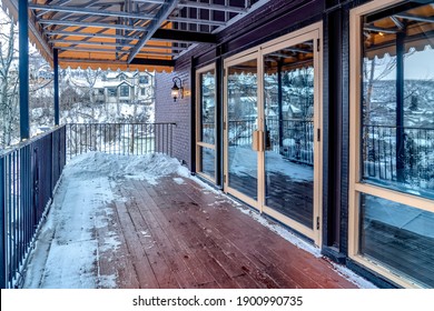 Front Deck Of Building With Double Glass Door And Snow On The Wooden Floor