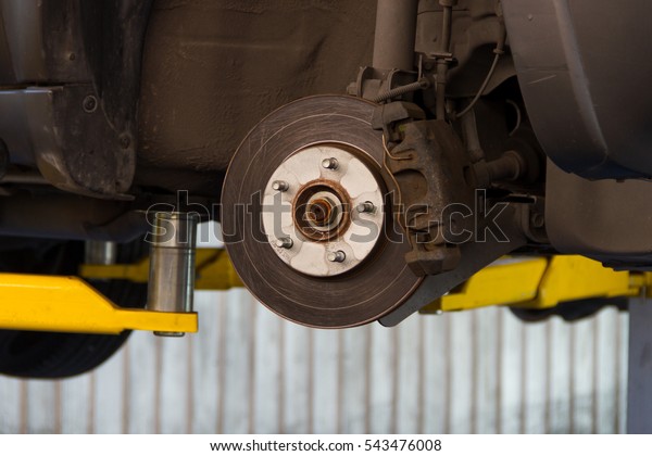 Front disc brake on car in process of new\
tire replacement
