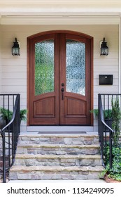 Front door, brown front dual doors with a nice stone staircase with black hand railing