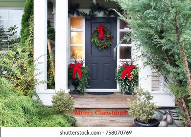Front door with a Christmas wreath and bows. Merry Christmas stencilled on the front step. 