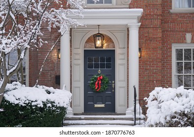 Front Door With Christmas Wreath With Snow Covered Trees