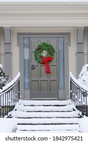 Front Door With Decorative Seasonal Or Christmas Wreath, And Snow Covered Steps