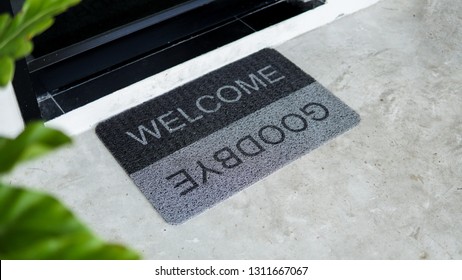 Front Door With Doormat Plants With Welcome,goodbye Written On It