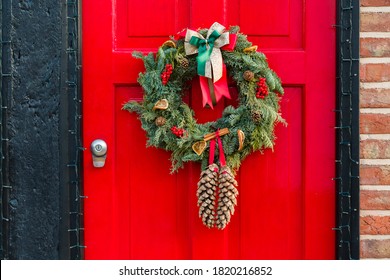 Front Door To An English Home Painted Red With A Christmas Wreath, Xmas Garland