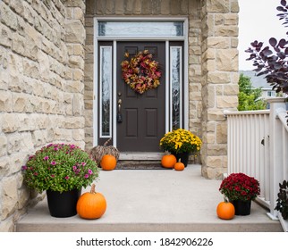 Front Door Of Home Decorated For Fall With Flowers And Pumpkins.