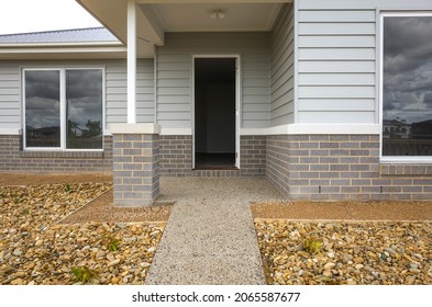 The front door and porch of a brand new timber weatherboard house. A classic Australian-style home. Concept of real estate investment, homeownership, and housing market. Melbourne, VIC Australia.