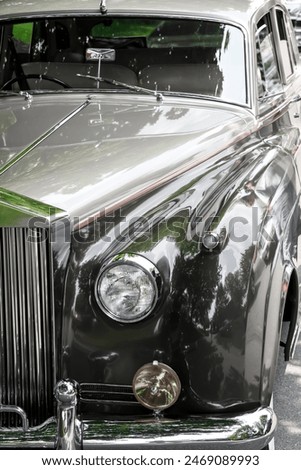 Front end close up view of shiny luxury classic car, desaturated.
