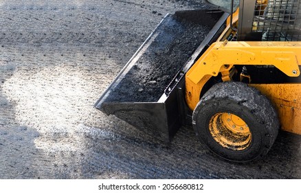 Front end loader carrying asphalt during paving