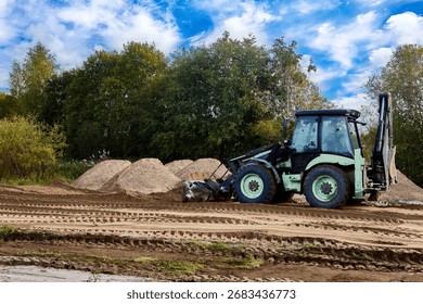 Front end loader performs finish grading by precisely redistributing loose sand layer and removing minor surface irregularities for optimal site compaction.