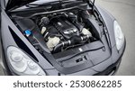 Front engine compartment of an used Germany car with clean components and assemblies plastic body under an open hood top view of auto after preparation for sale. Detailing.        