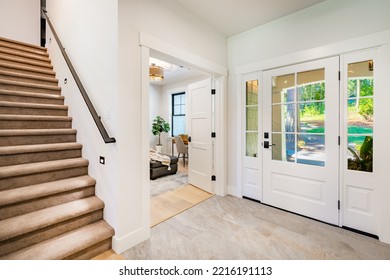 Front Entry Door Of A Modern Home Showing Interior Staircase And Porch 