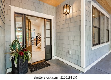 Front entry door of a modern home showing interior staircase and porch  - Shutterstock ID 2216191137