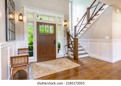 front entry foyer of a luxurious home rich wood tones staircase bench with a welcoming feel - Shutterstock ID 2185172053