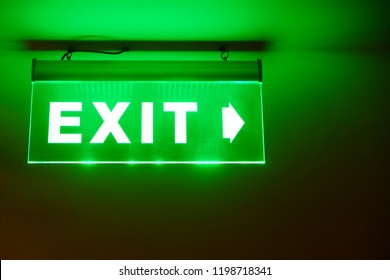 Front face raised view of green emergency fire exit sign hanging on the ceiling