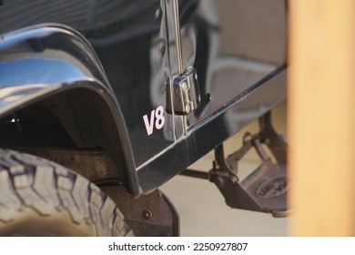 The front fender of a truck with the letters V8 written on it.