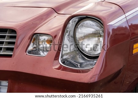 front headlight is a close-up of an old powerful classic American car