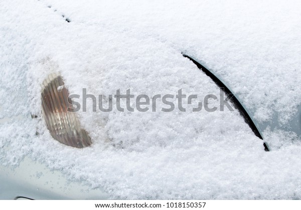 Front headlight\
covered by snow at winter\
time.