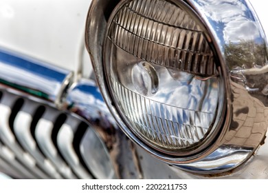 Front Headlight Of A Retro Car With A Beige Tint Close-up With A Radiator Grill