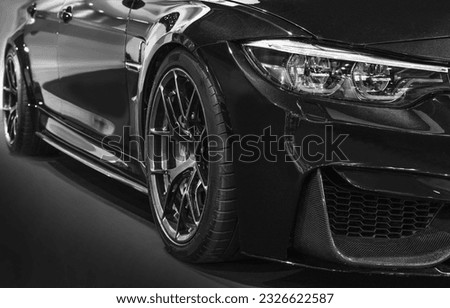 Front headlights of black modified car on black background
