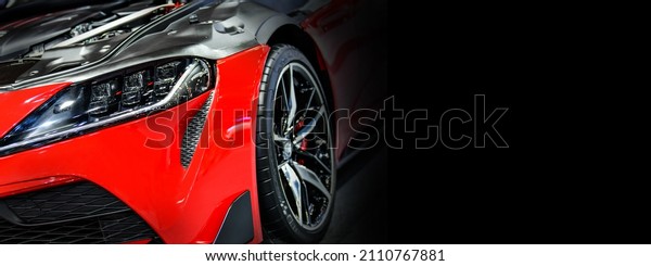 Front headlights of red modify car on black
background, copy space	