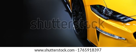 Front headlights of yellow modern car on black background,copy space